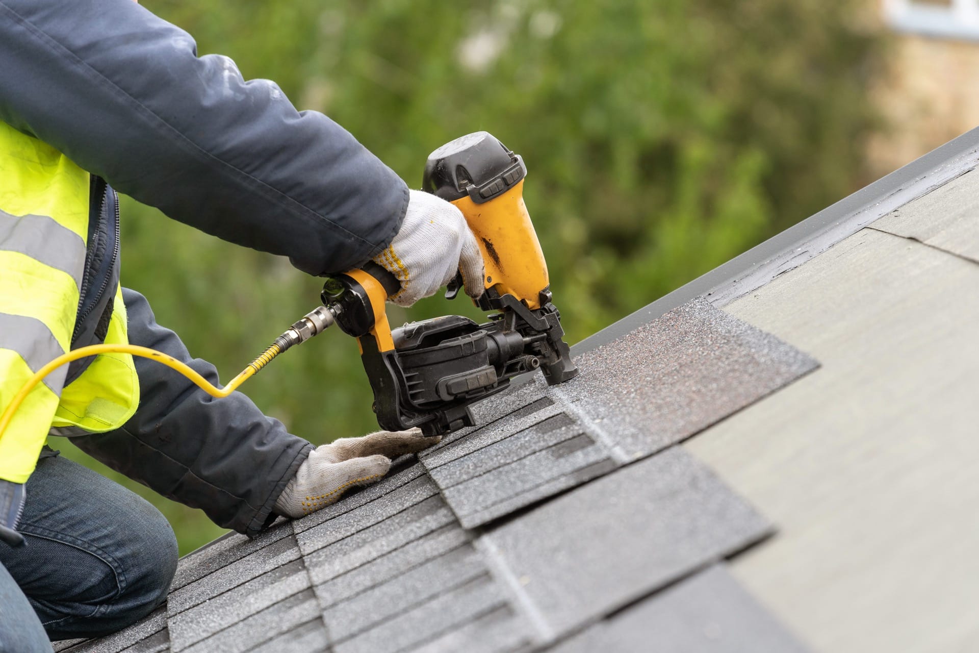 A roofer works on a roof